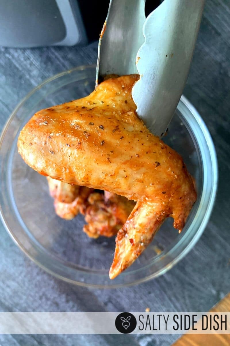 air fryer chicken wing with tongs