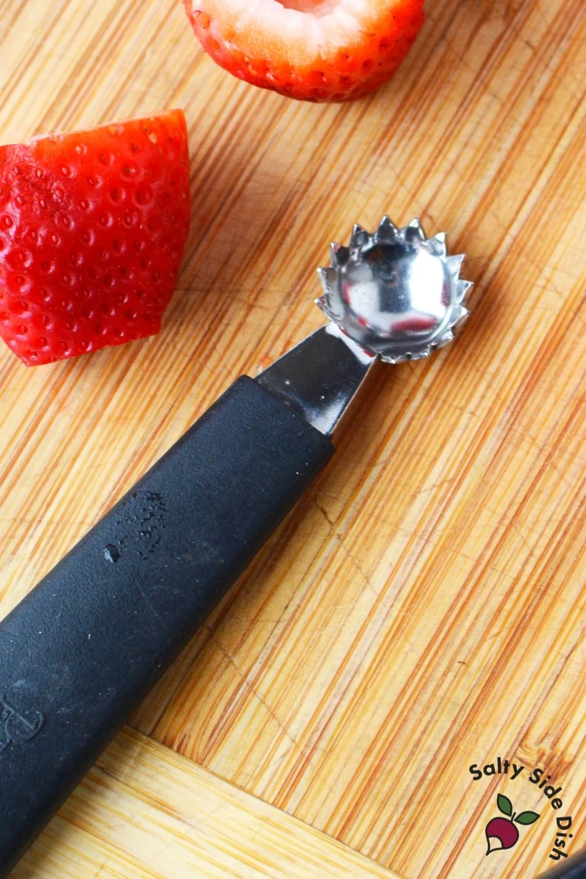 strawberry huller laying on a cutting board