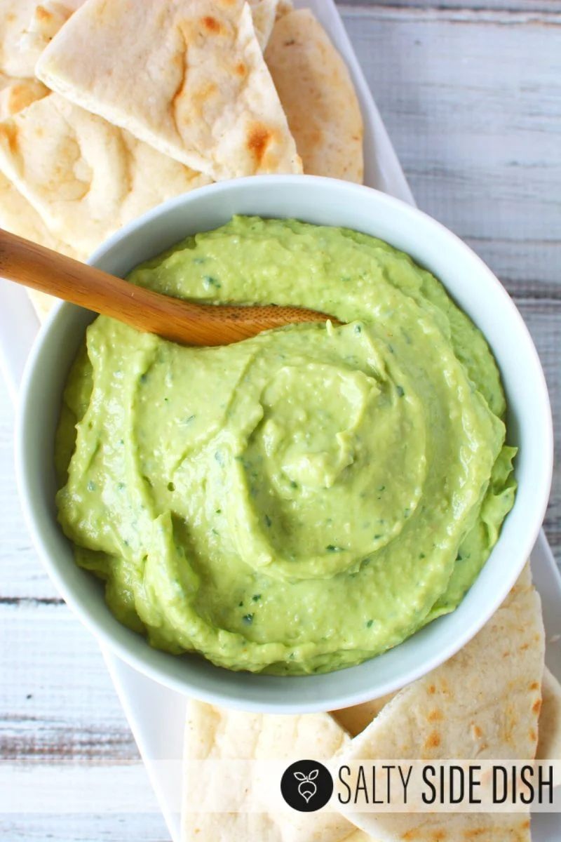 Avocado Tzatziki Dip in a white bowl with pita bread on the side