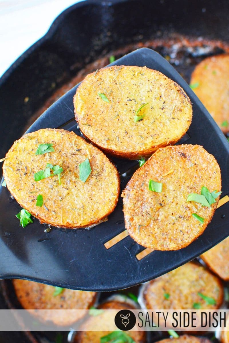 Finished melting potatoes with soft center sitting on a spatula, ready to serve