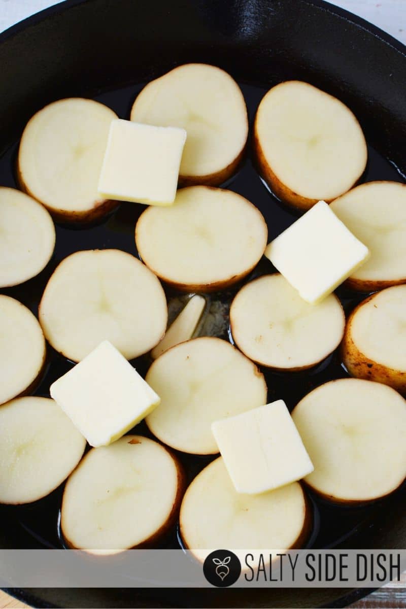 newly cut Russet potato slices with butter in a cast iron pan
