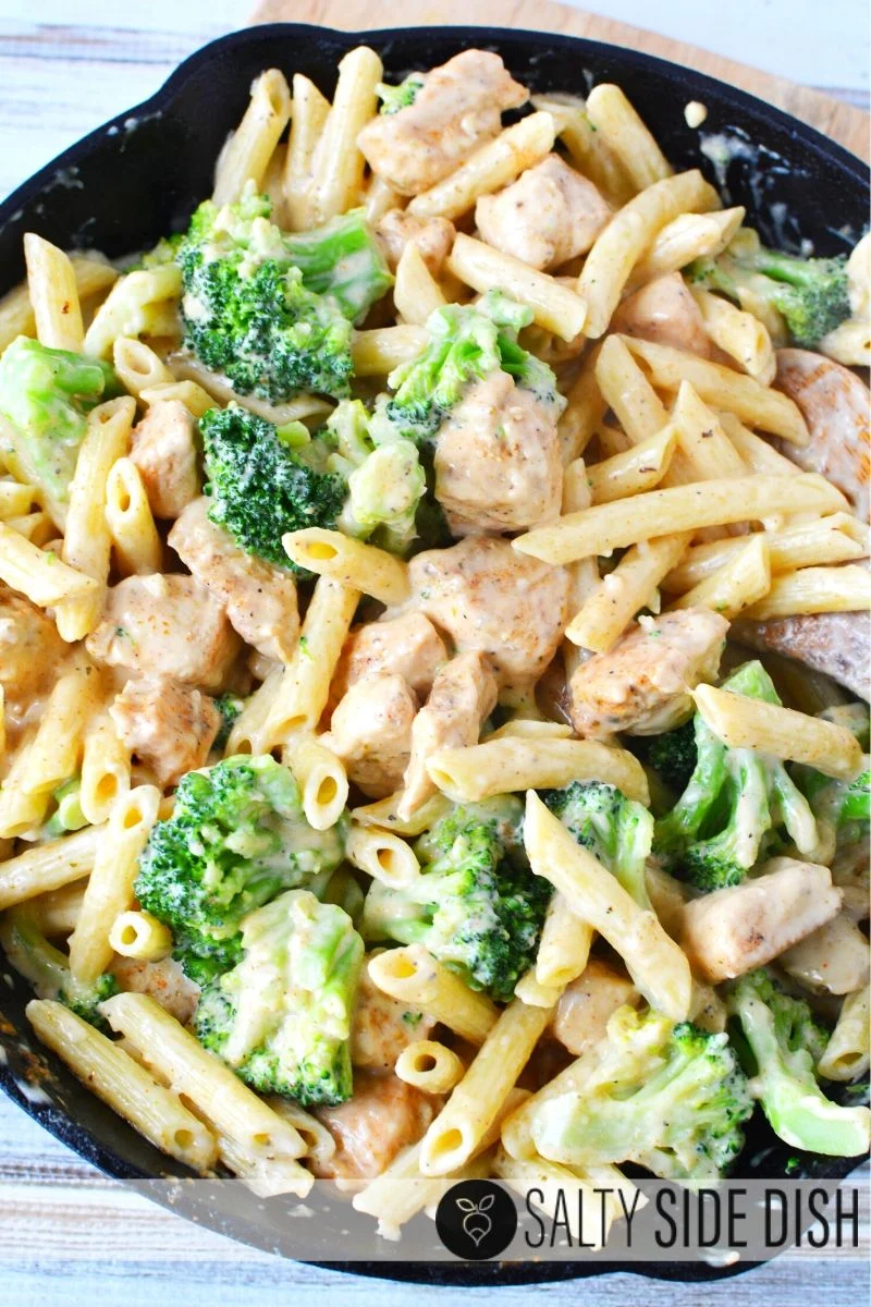 Penne pasta with broccoli, Cajun chicken, already cooked and sitting in a one pot pan