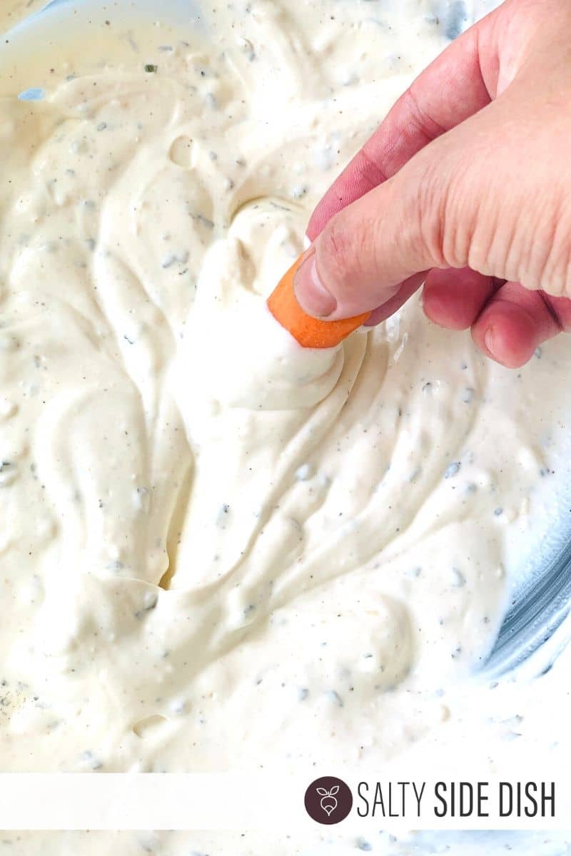 Greek Yogurt dip with mini carrot being dipped into it