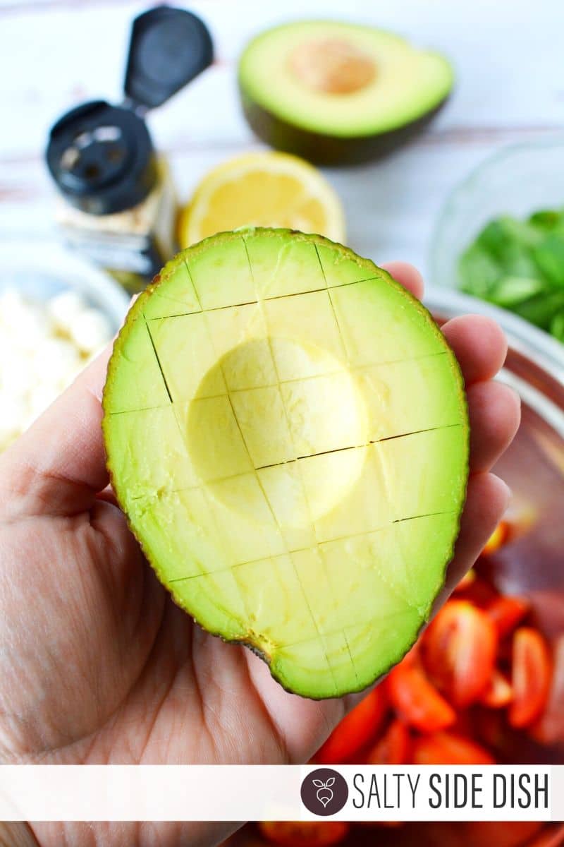 Avocado being cut and held to show cuts
