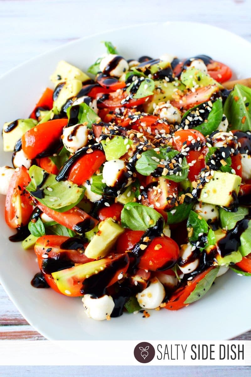 Everything Bagel seasoning being dumped on Caprese Salad