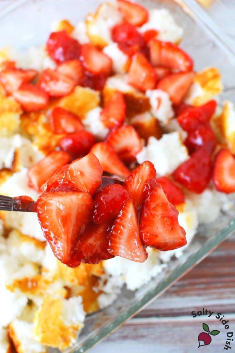 scoop strawberries into layered angel food cake
