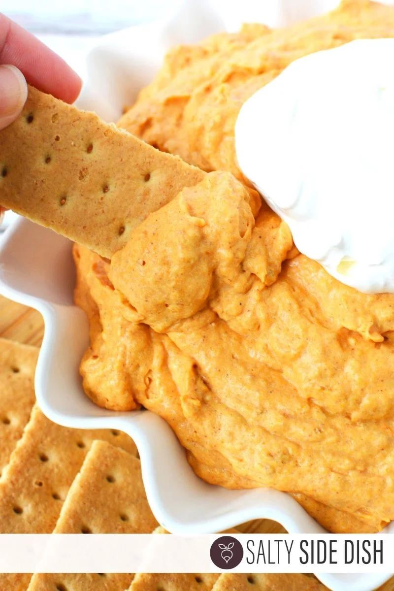 Dipping a graham cracker into pumpkin fluff