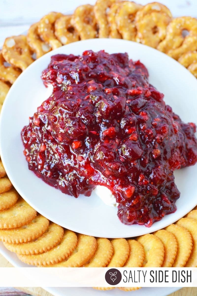 Dump delicious cranberry dip on top of cream cheese spread and serve with pretzles
