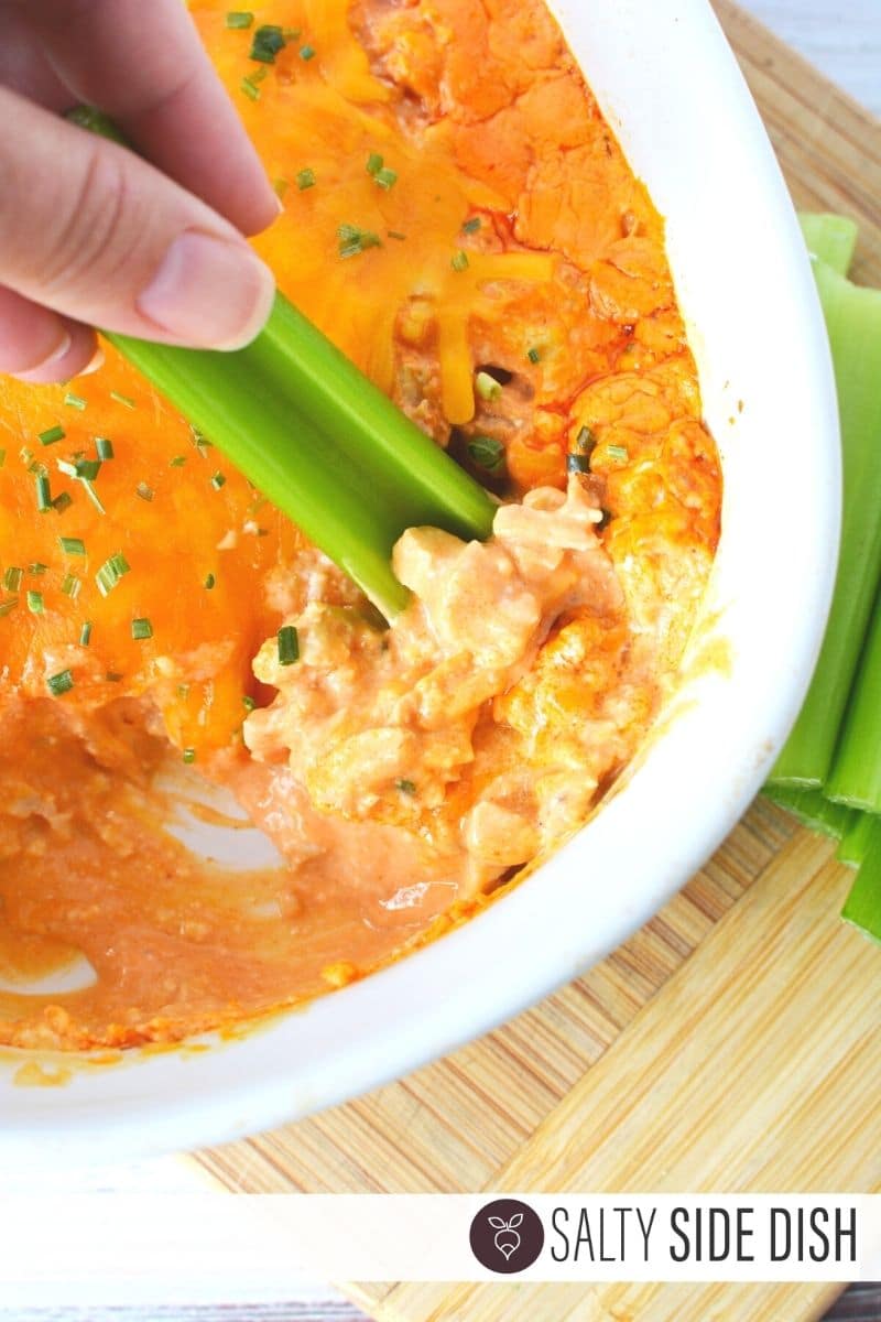 Buffalo Chicken Ranch Dip being dipped with a celery stalk