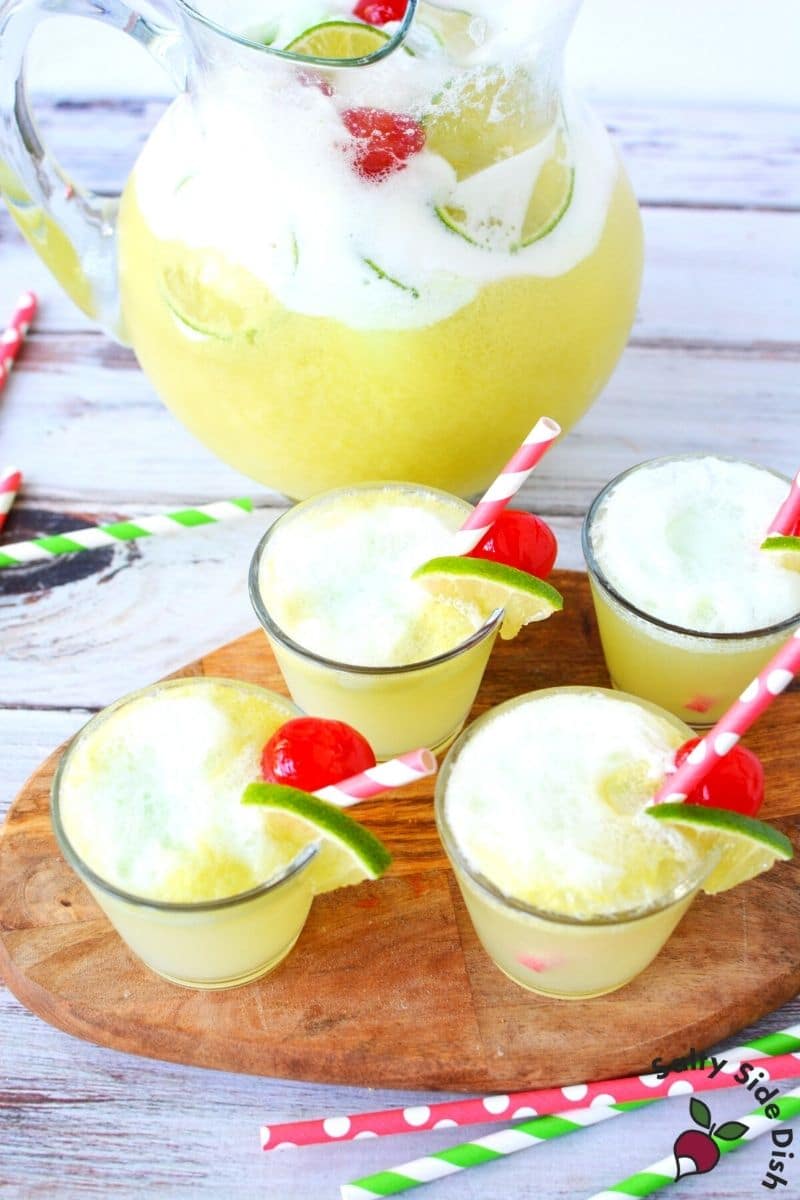 lime sherbet made with sprite in pitcher and 4 glasses ready to serve.
