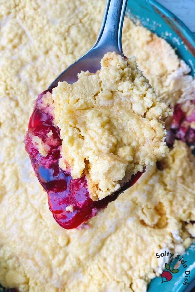 scoop of Dump cake with cherry pie filling, whipped cream cheese, and vanilla cake - popular viral recipe for dump cake