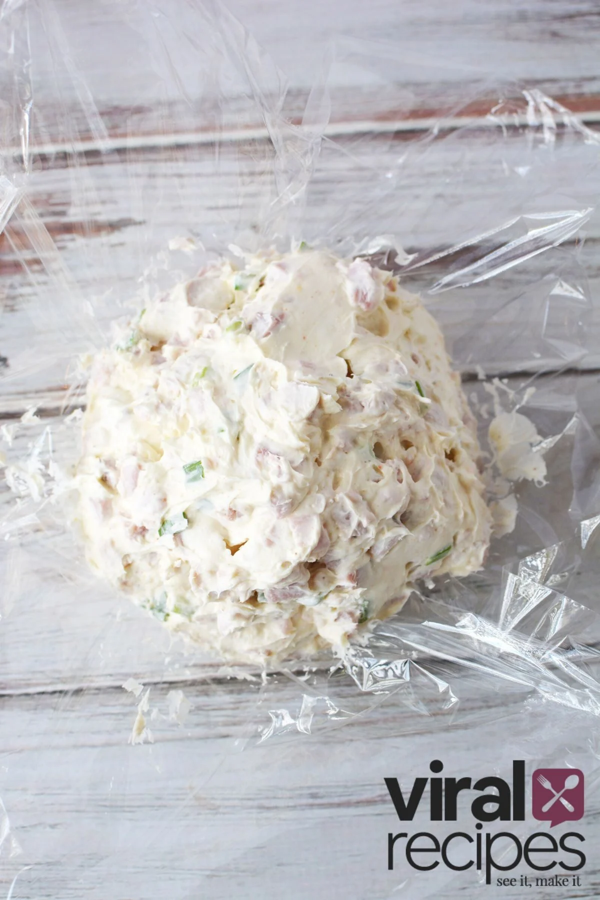 cream cheese and ham ball on plastic wrap.
