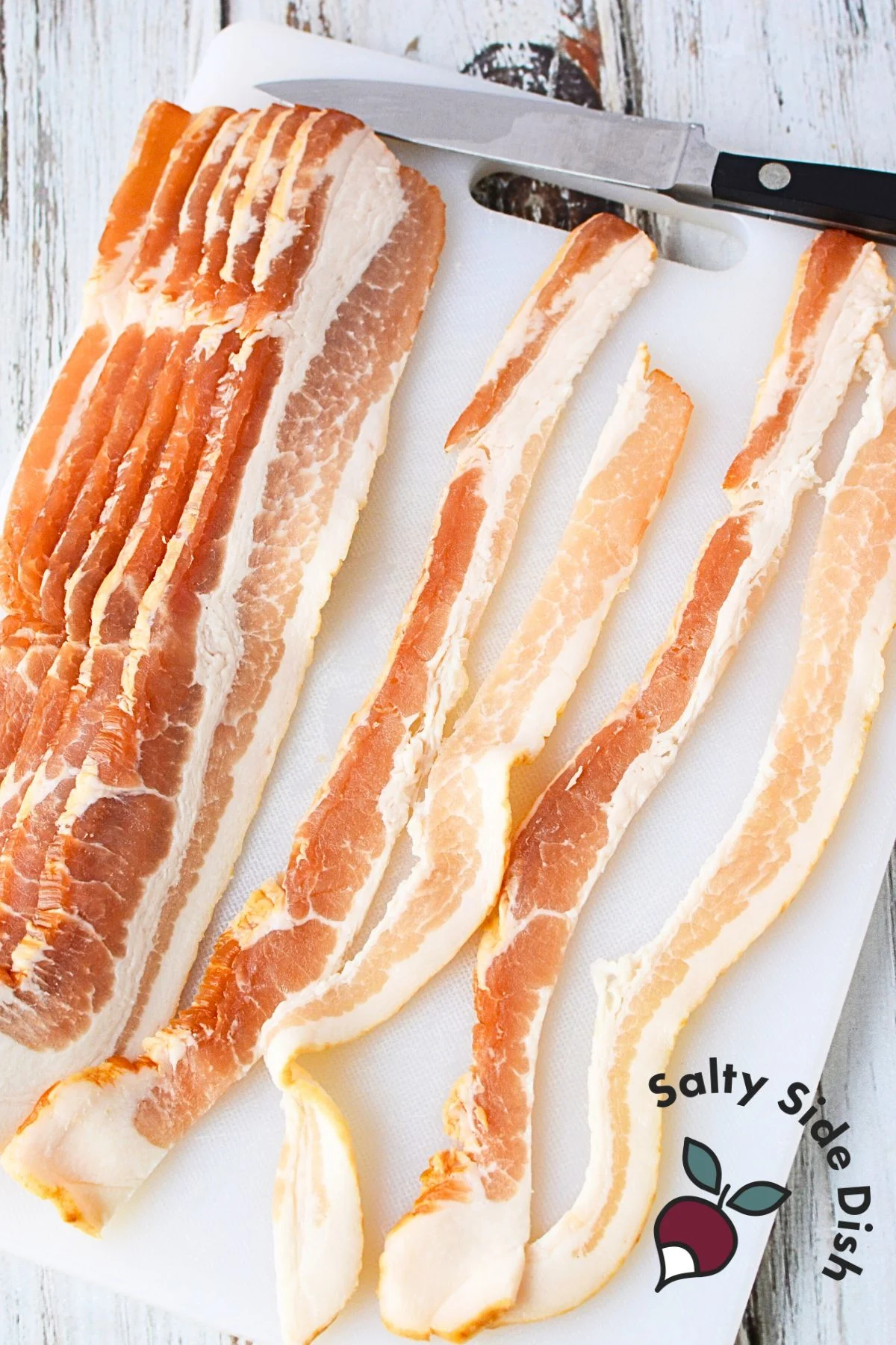 cutting strips of bacon longways with cutting board and knife in the image.