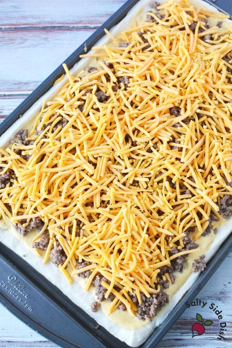 shredded cheese and ground beef baked on a pizza dough