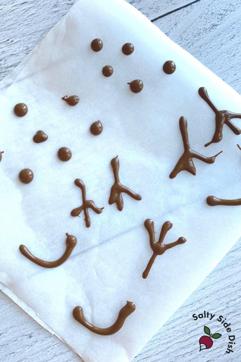 bits of snowman hands and eyes on parchment paper