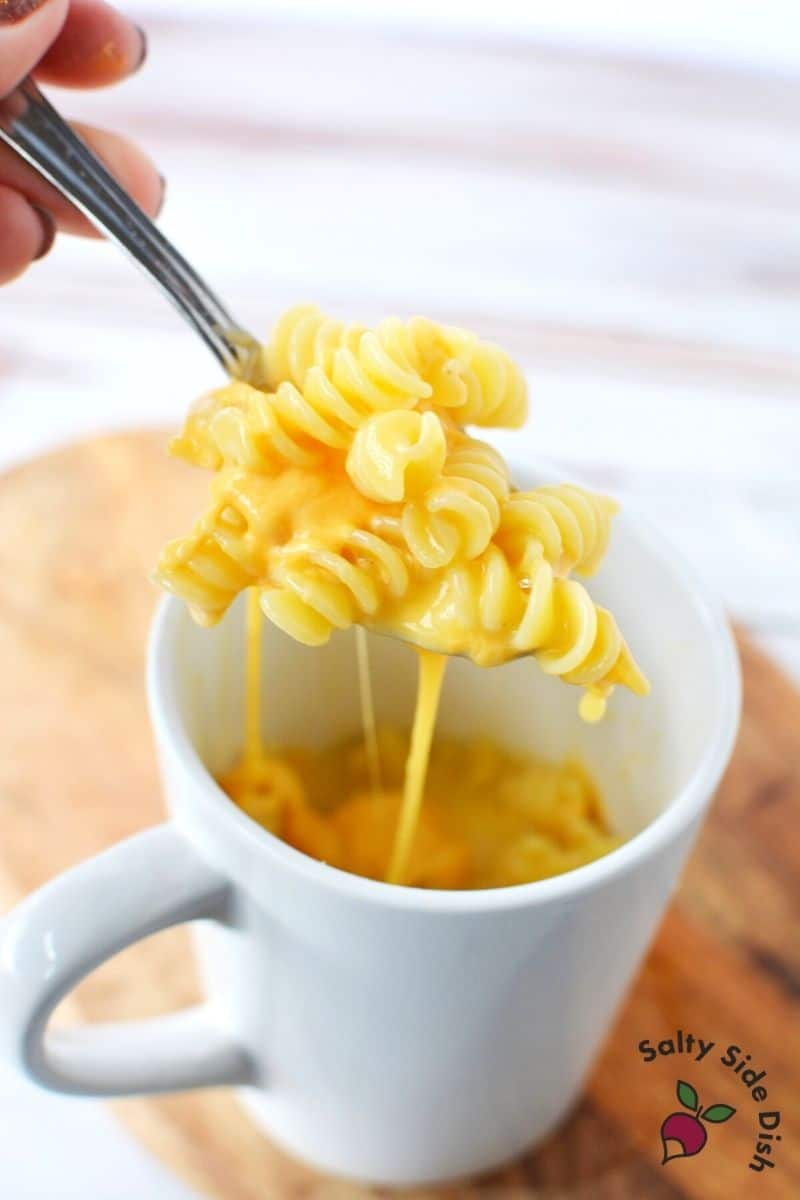 Mac and Cheese in a Mug with dripping cheese sitting on a spoon