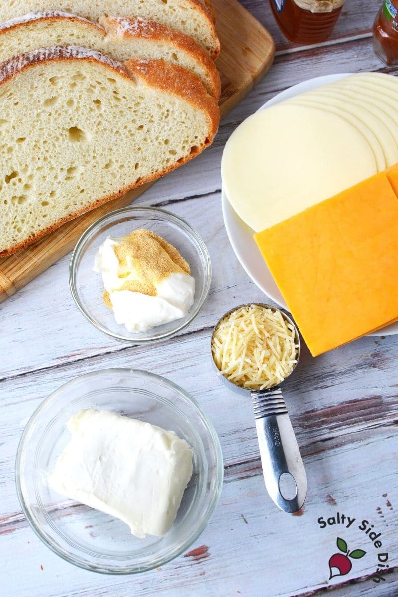 spread out garlic spread, cream cheese and artisan bread, cheeses make up this delicious and easy disney grilled cheese recipe
