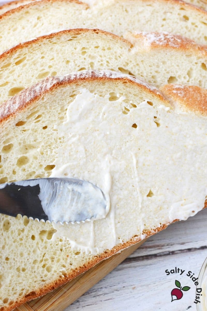 spreading mayo on the outside of the bread