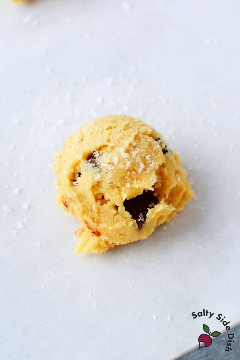 portioned out chocolate chip cookie dough on a piece of parchment paper.