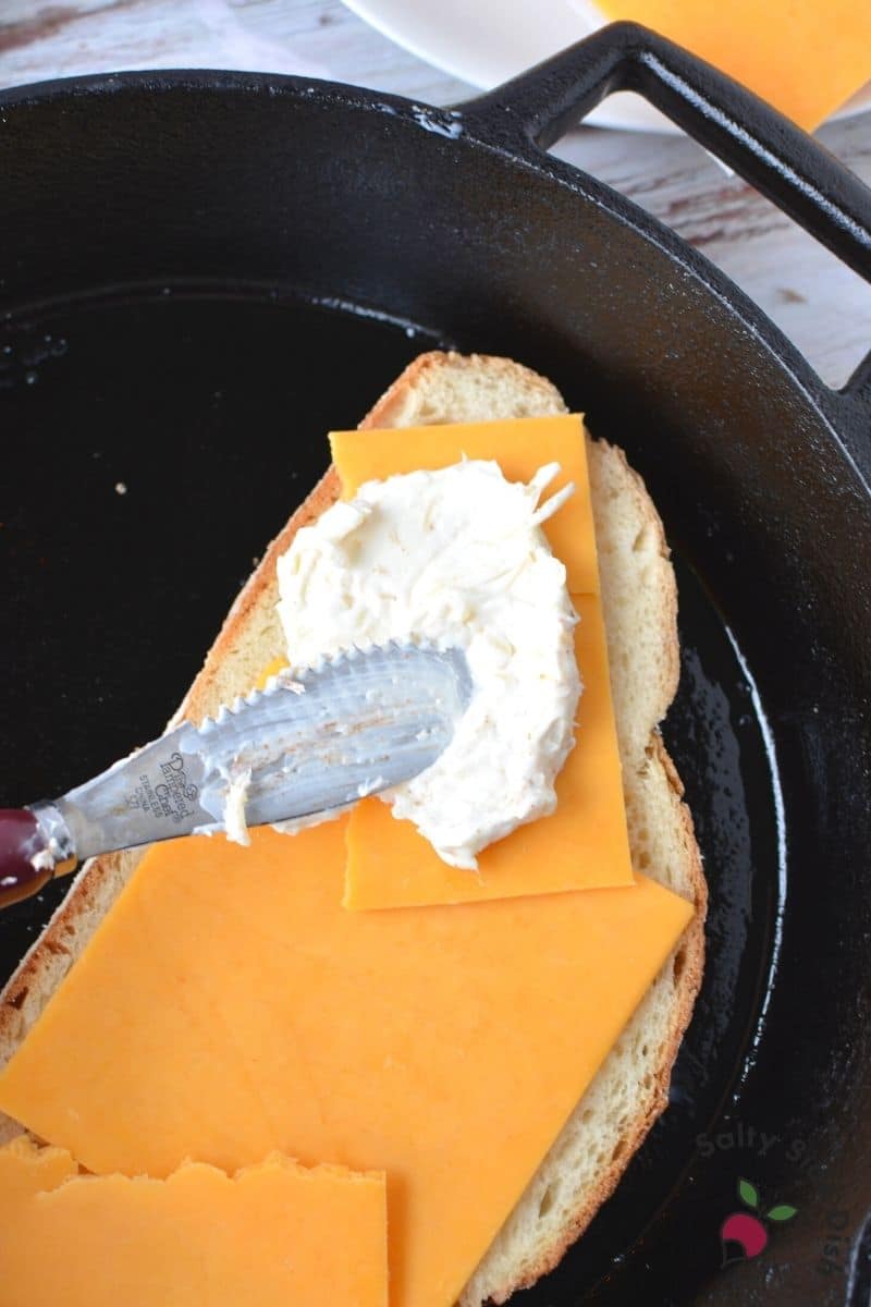 cheesy cream cheese spread is thick over cheddar cheese slices