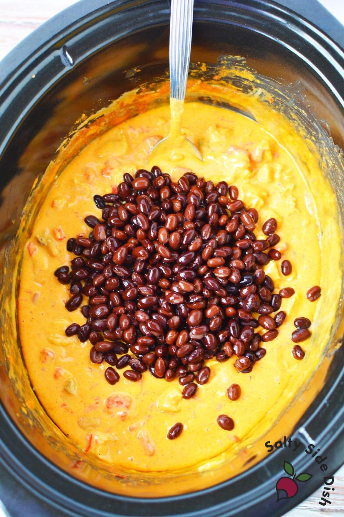 added black beans into slow cooked crock pot cheese