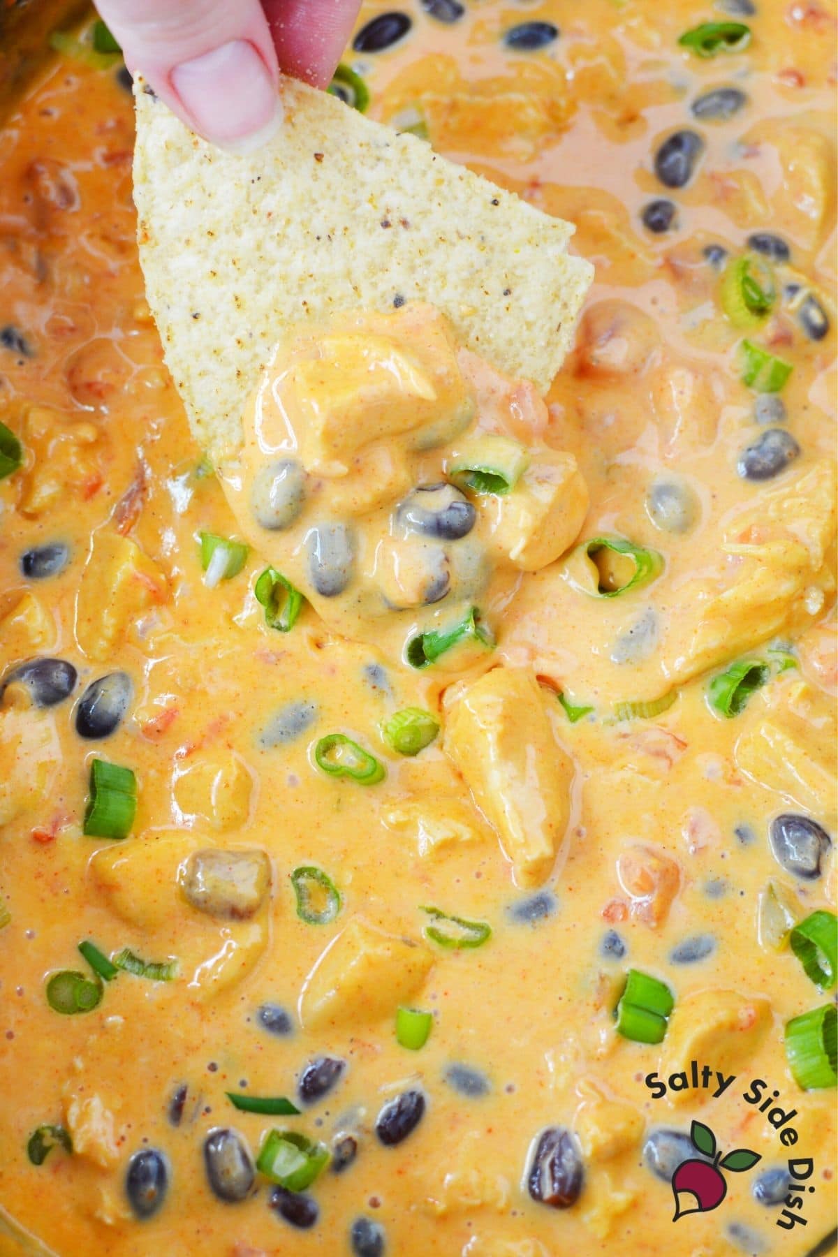 easy to make nacho cheese dip being dipped by a chip