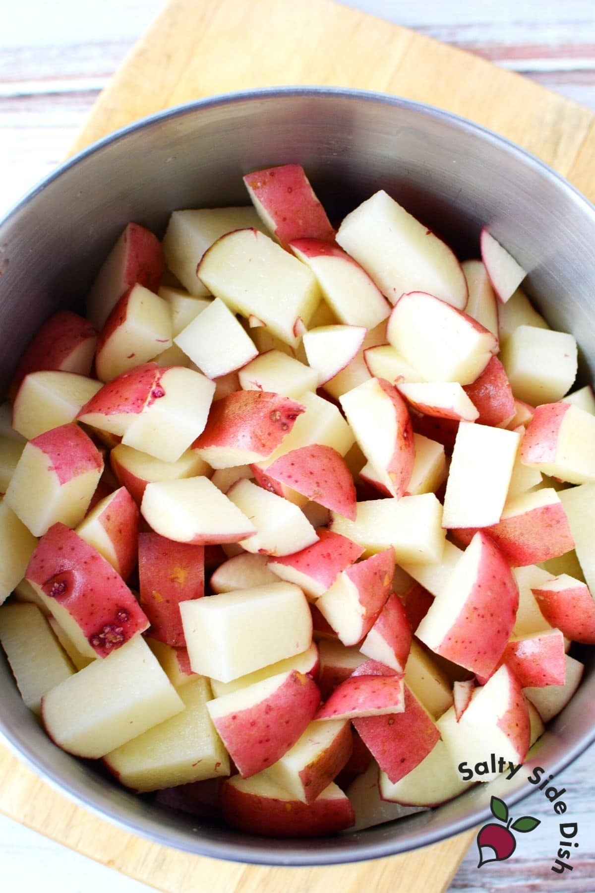 prepping boiled red potatoes in a pot