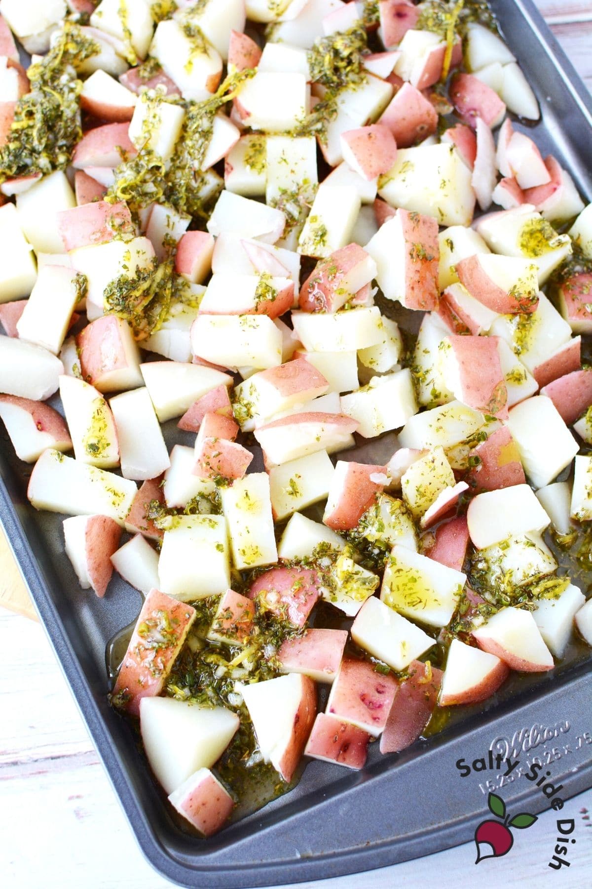 pouring lemon and herb onto sheet pan
