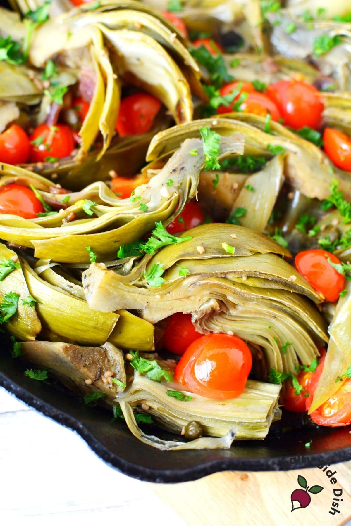 braised artichokes warm side dish in a cast iron skillet