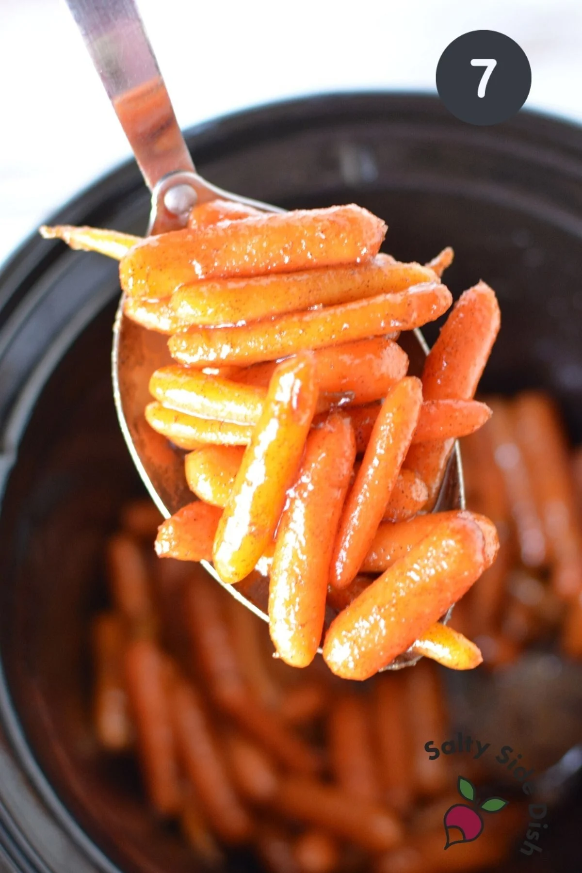 carrots being spooned out of crock pot.