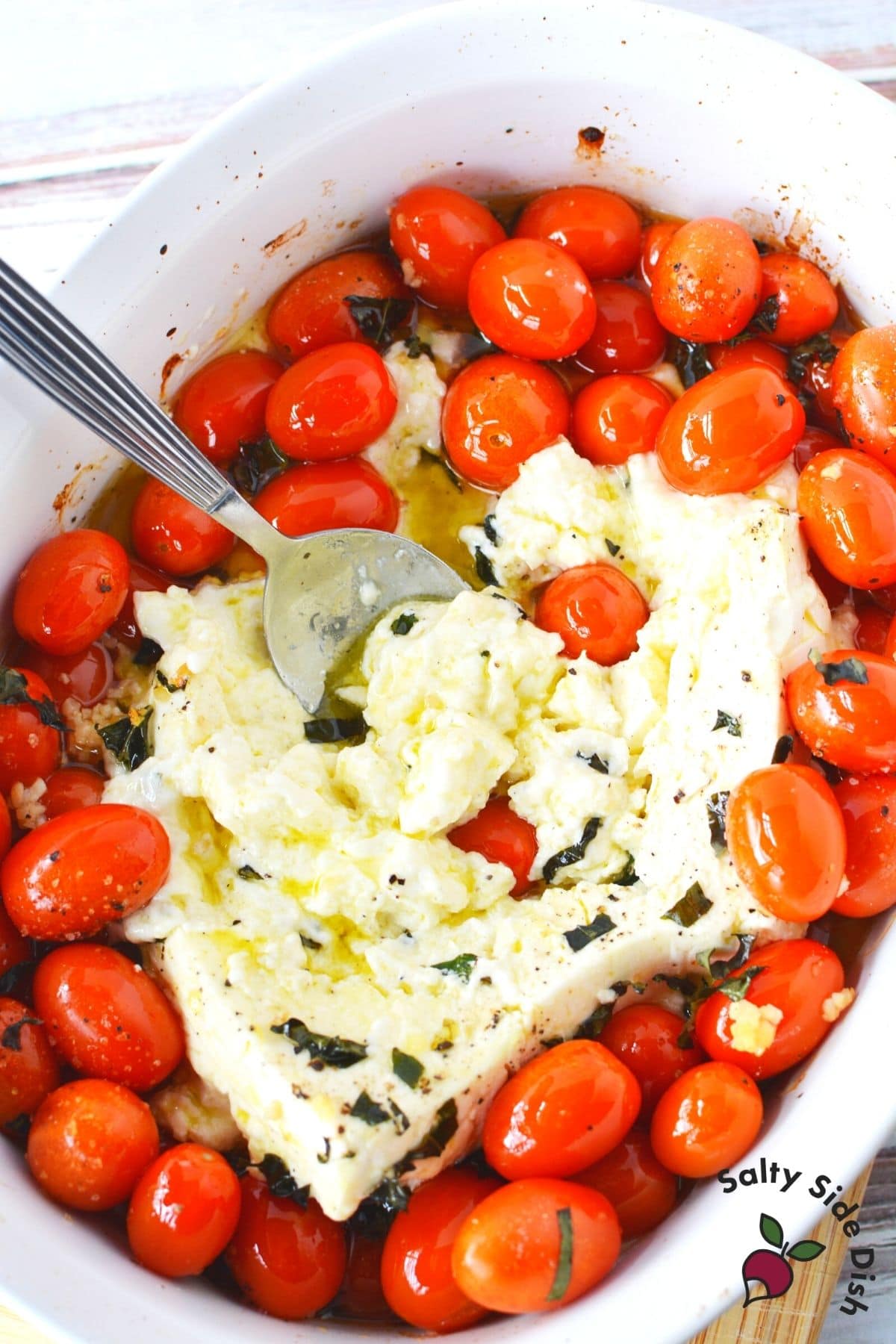 stirring feta cheese in casserole dish