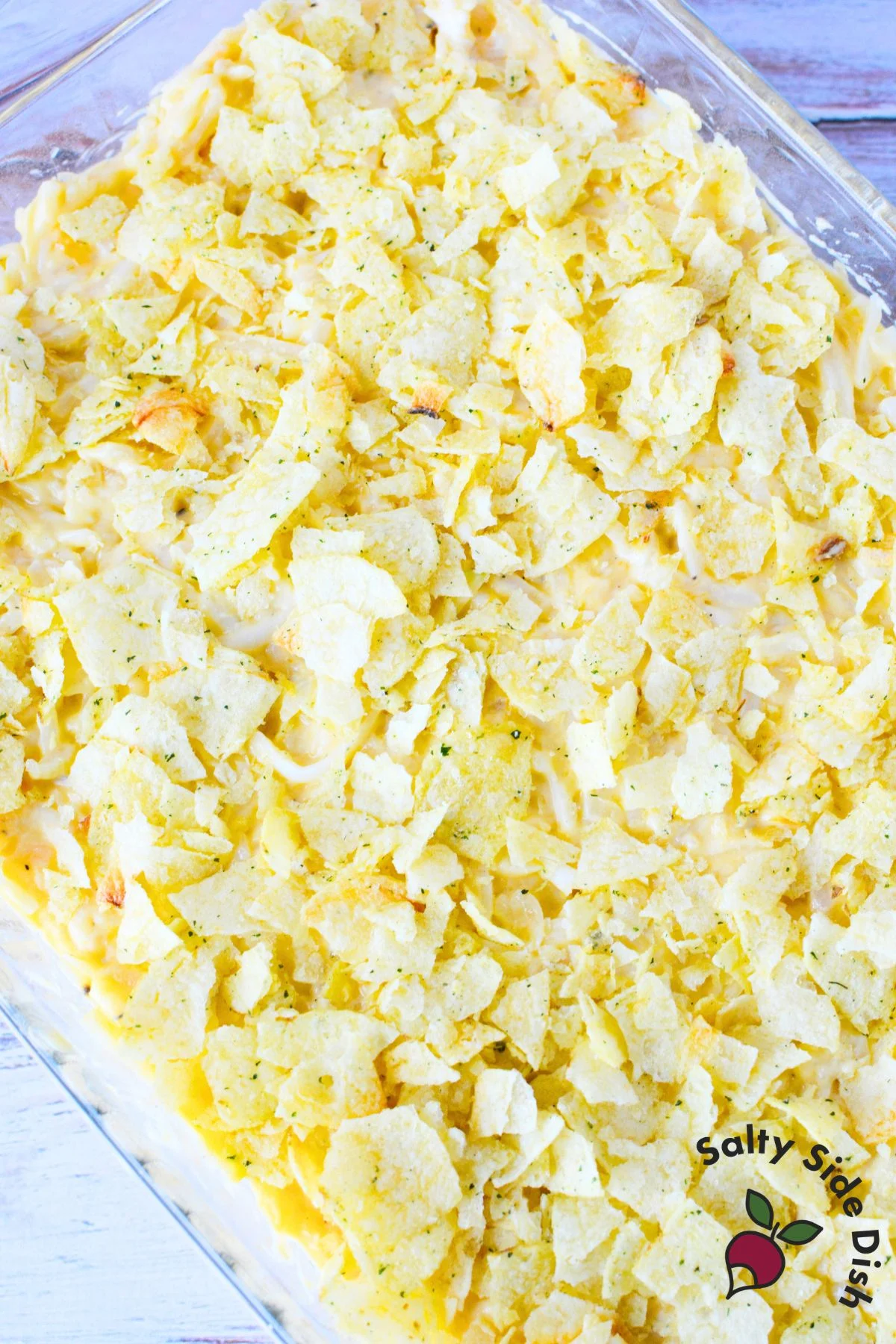 Baked funeral potatoes with crispy chip topping and creamy hash brown filling in a 9x13 dish