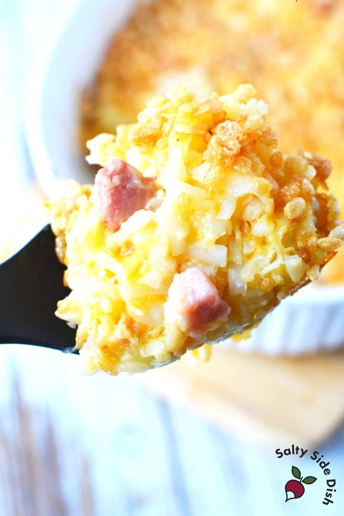 ham and potato casserole recipe with rice krispie topping on a spoon.