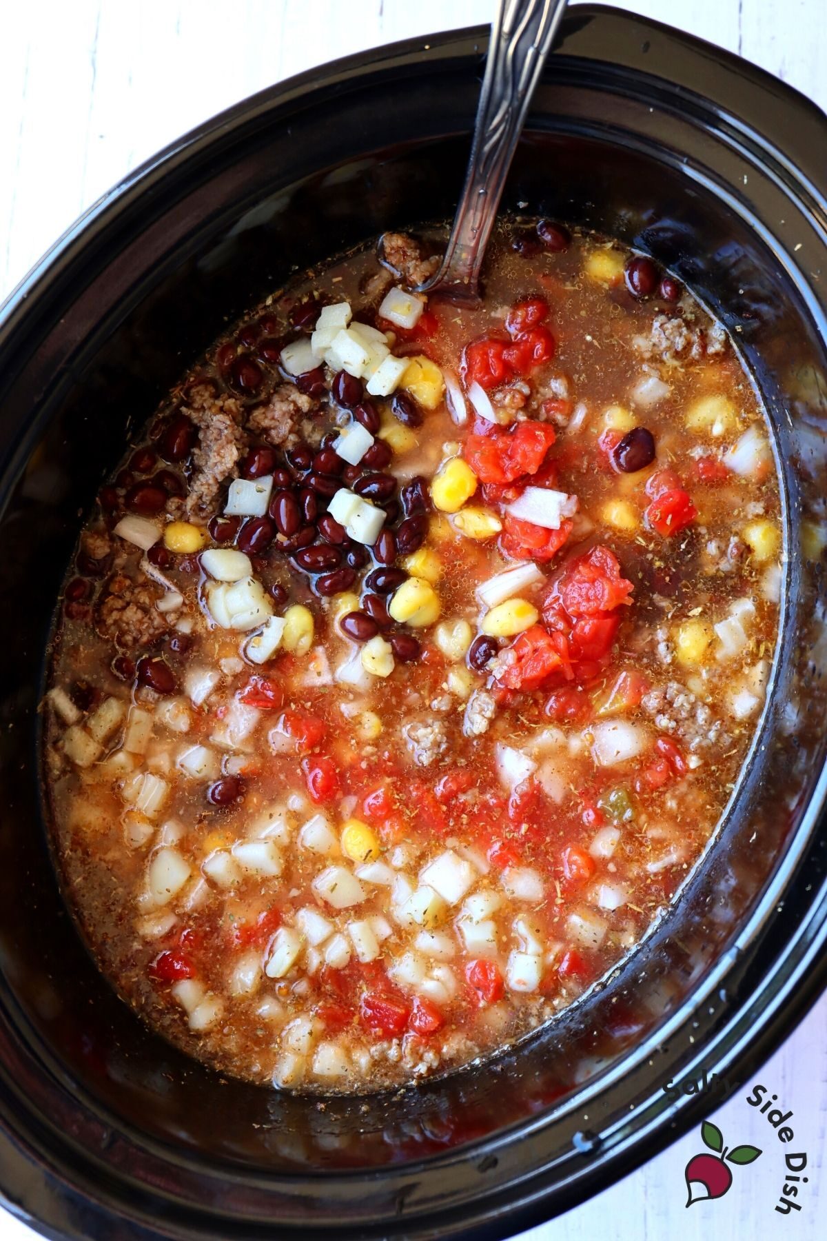 easy black bean soup in a slow cooker being stirred