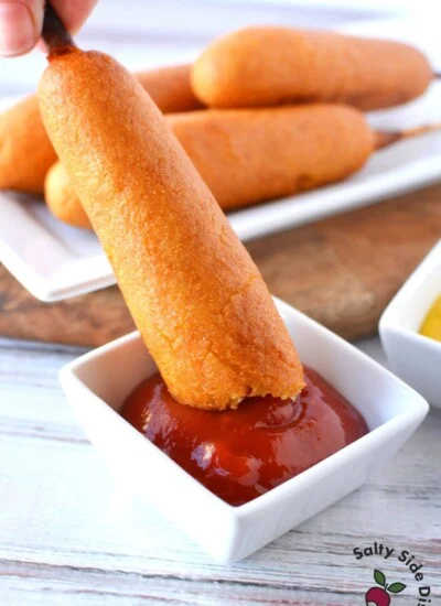 corn dogs being dipped into ketchup
