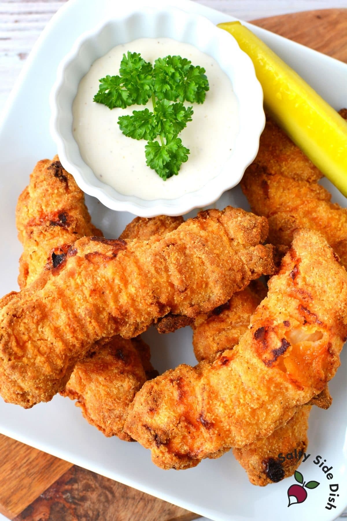 plate of chicken tenders cooked in air fryer with side of sauce