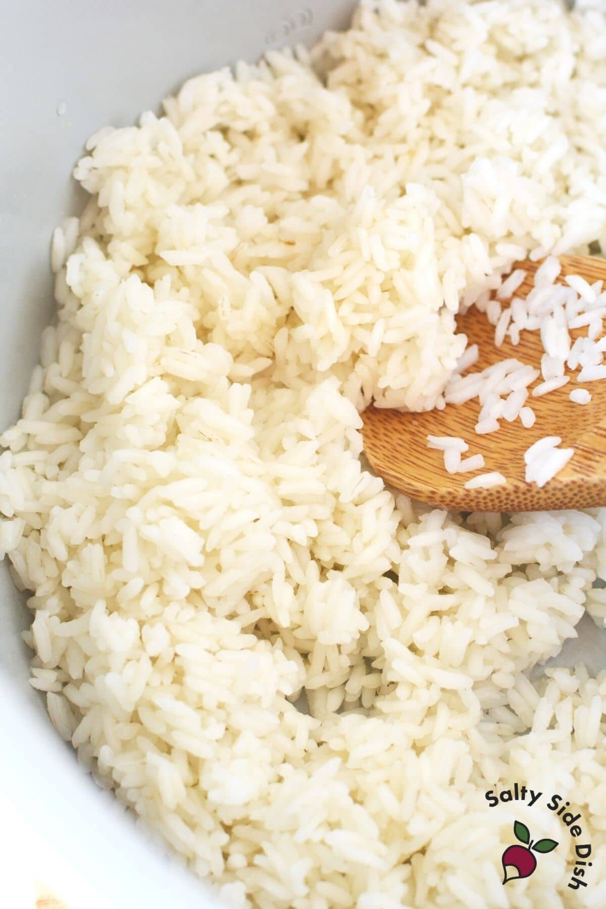 rice in a ninja foodi inner pot and wooden spoon