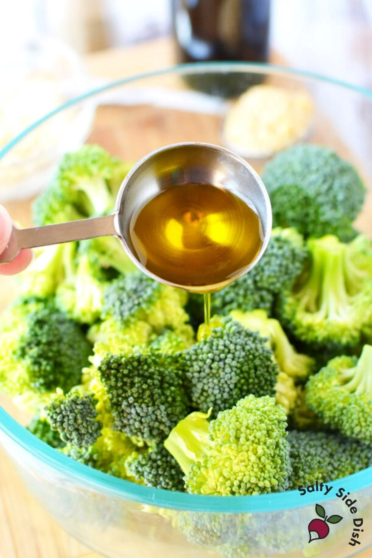 Pouring EVOO on broccoli before putting into the oven