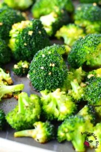 oven roasted broccoli with Parmesan cheese laying on a pan