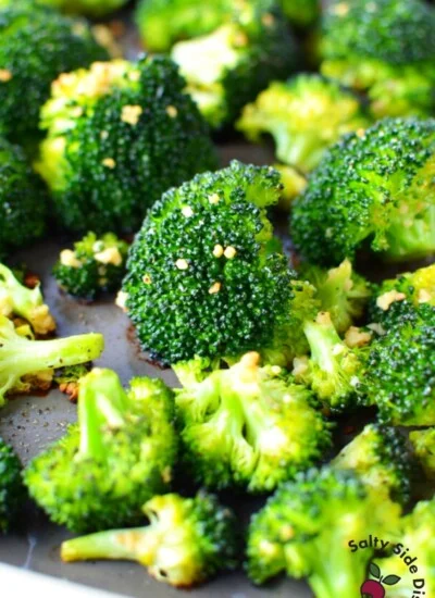 oven roasted broccoli with Parmesan cheese laying on a pan