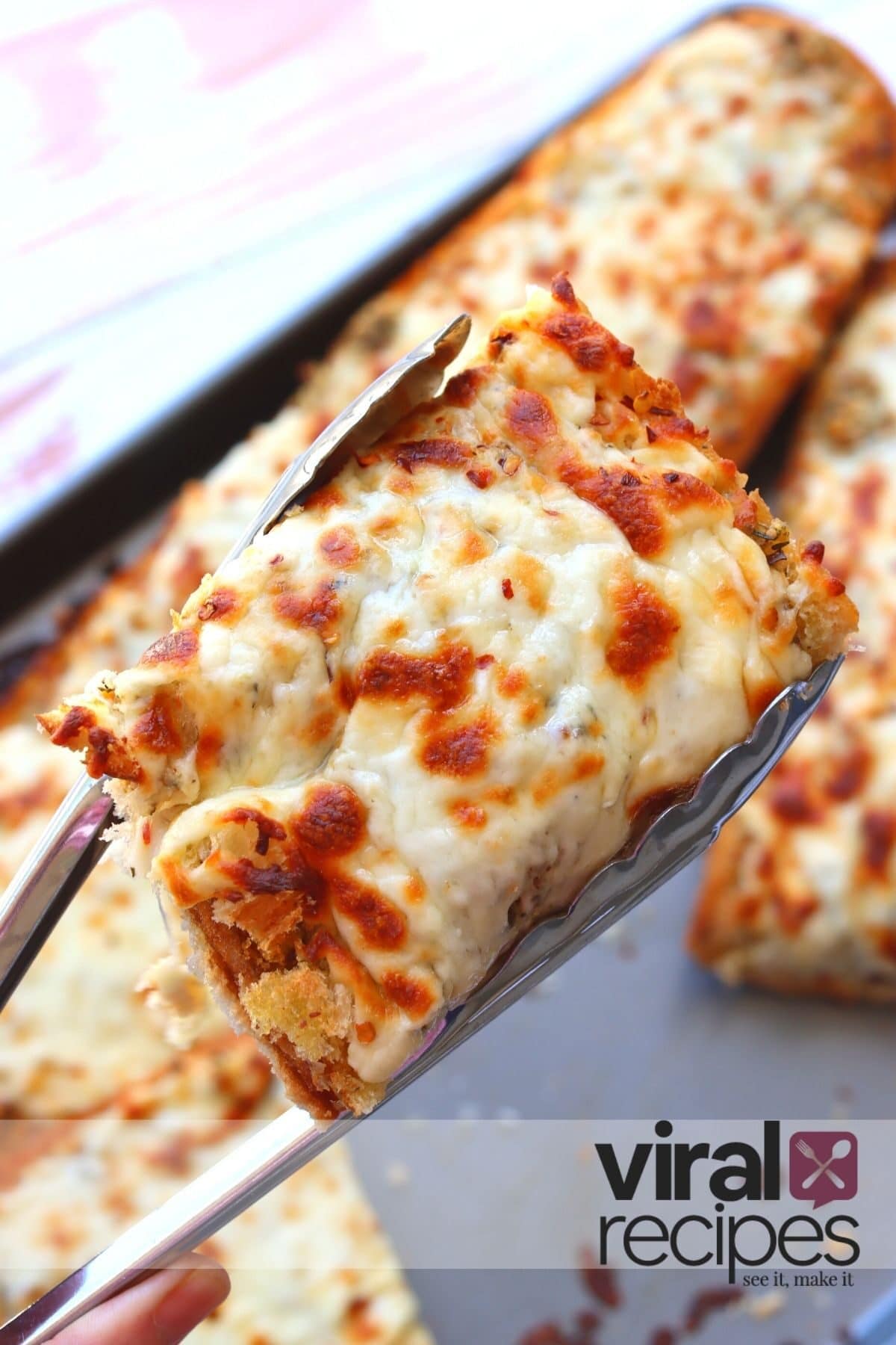 tongs holding hot cheesy garlic bread
