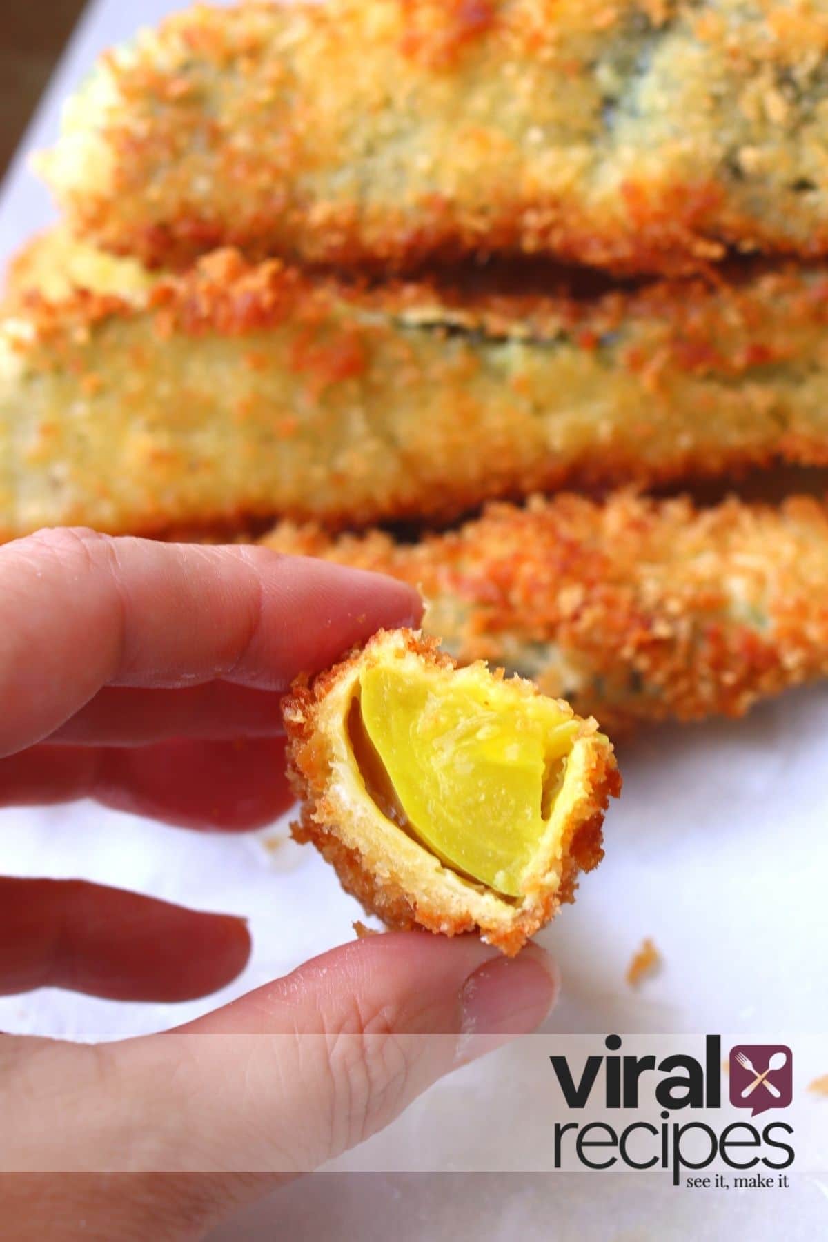Fried pickle spears cut in half with pickle showing and golden crispy panko crumb outside.