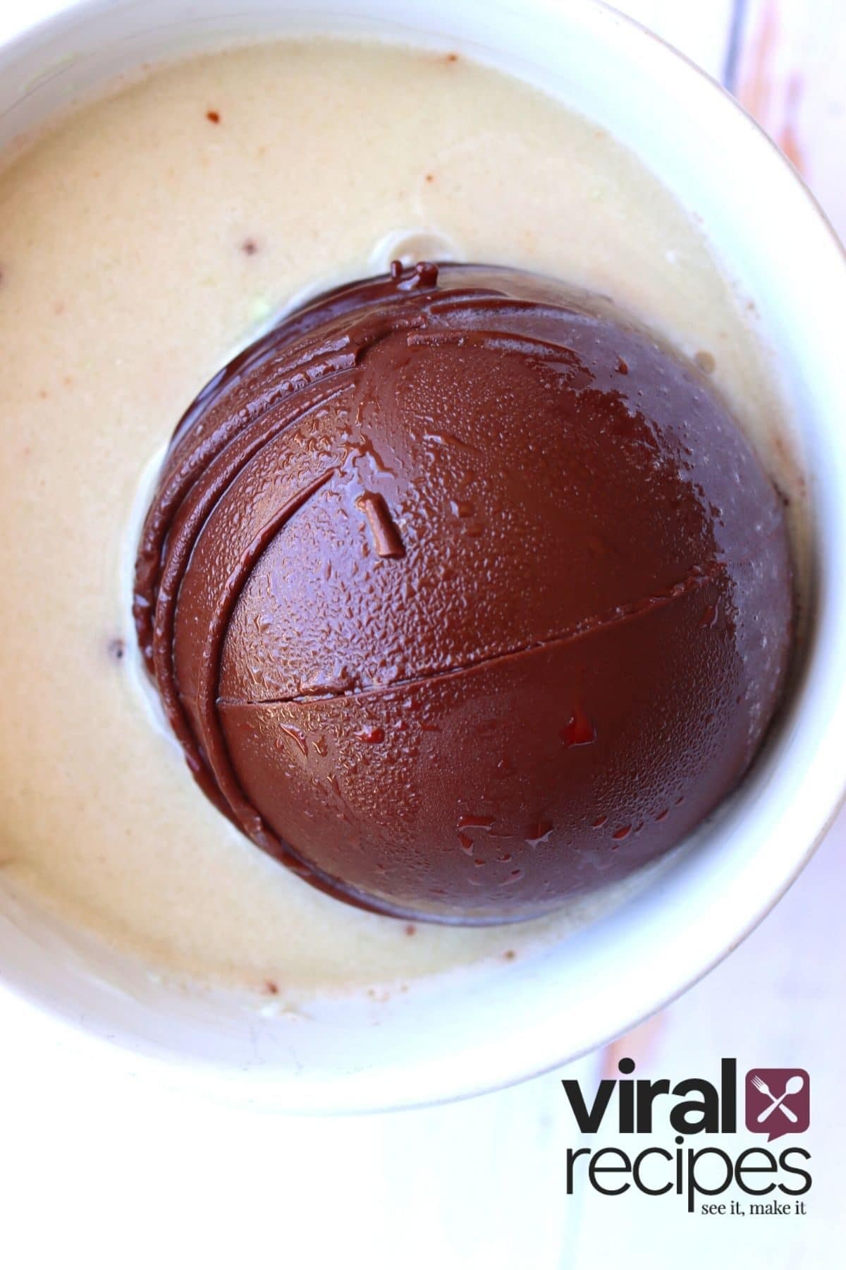 tiktok hot chocolate bomb sitting in a glass of milk
