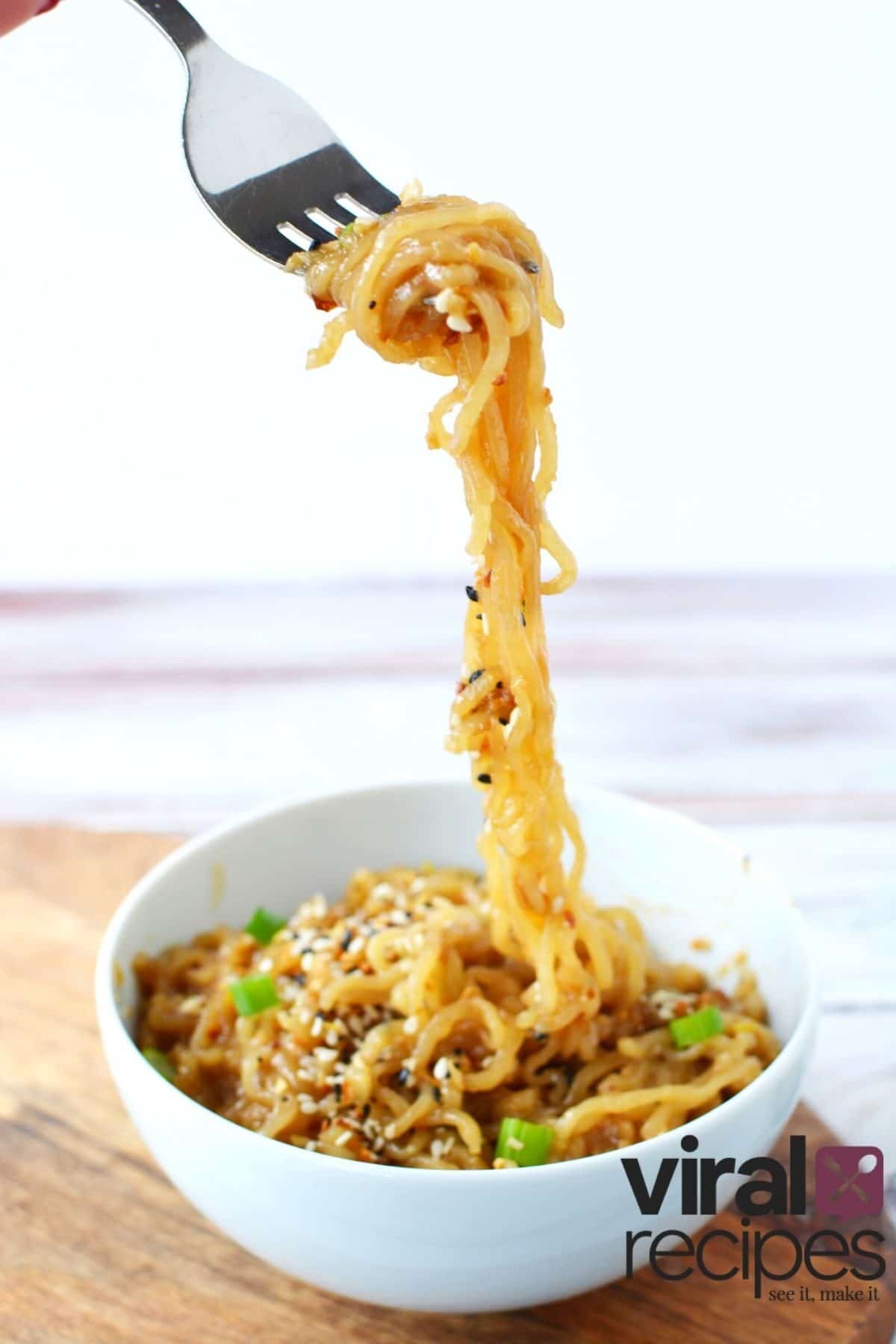 big fork full of ramen noodles in a white bowl