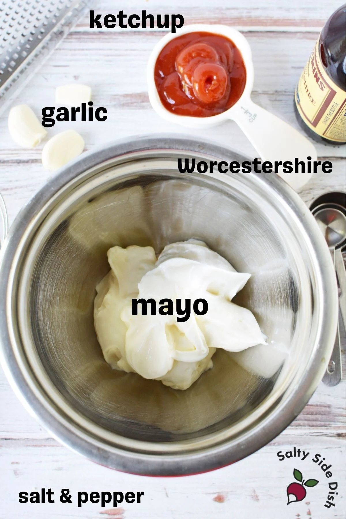 ingredient shot included measured out ketchup, silver bowl of mayo, garlic on table and a slight view of measuring cups on the right