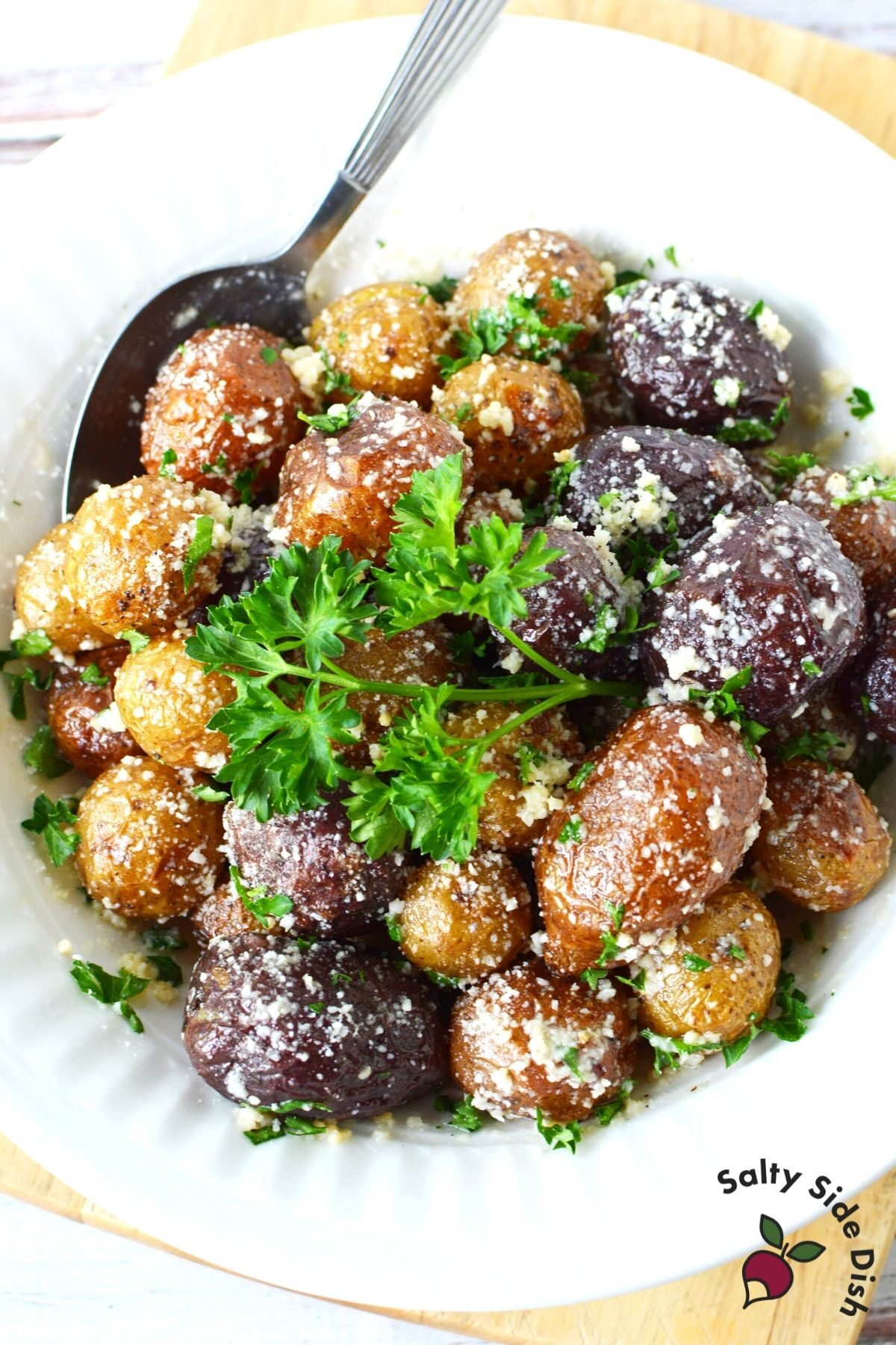 white bowl with mini baked potatoes and spoon