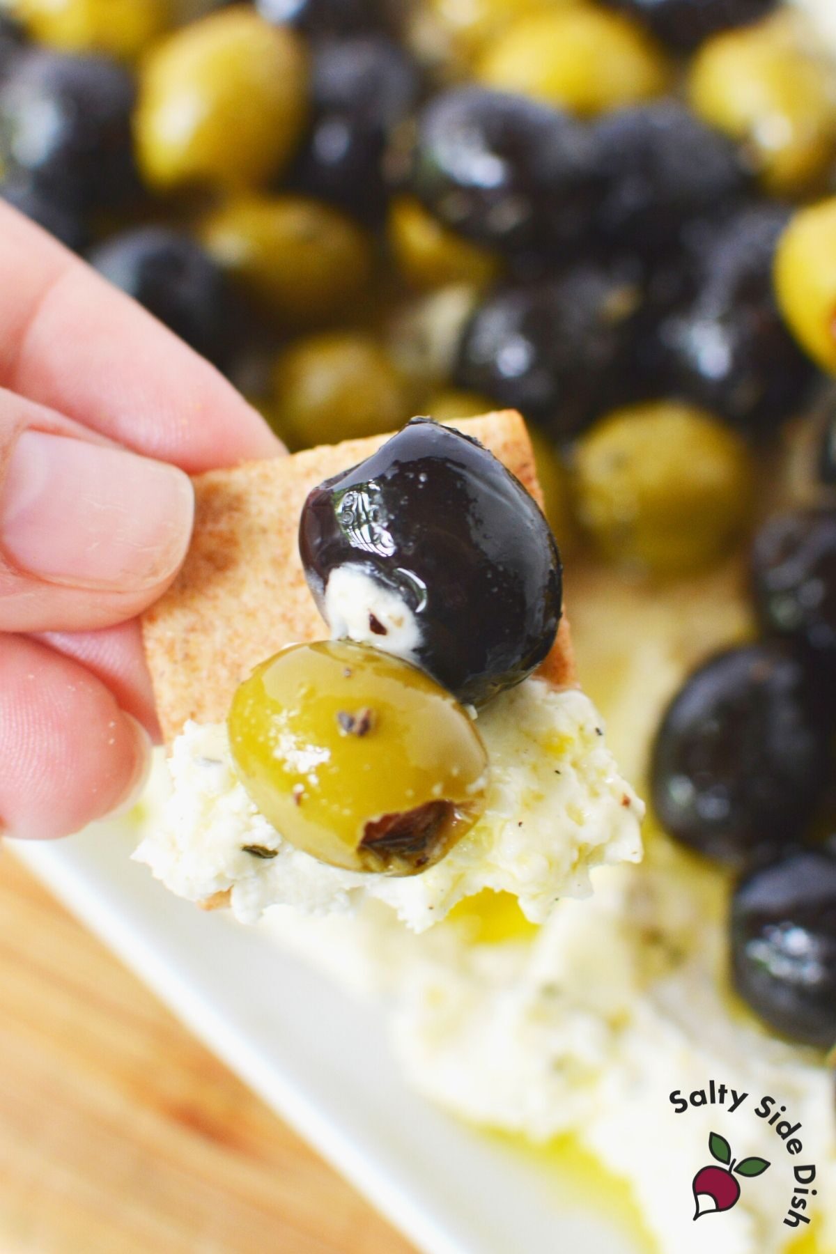 dipping a cracker into feta dip
