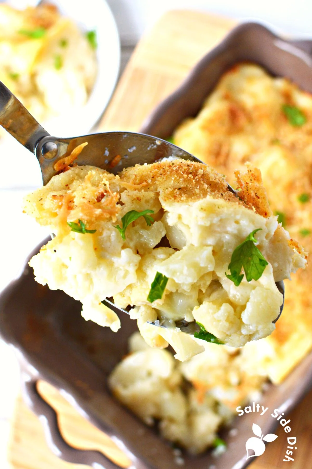 scoop of cauliflower and roux in a metal spoon.