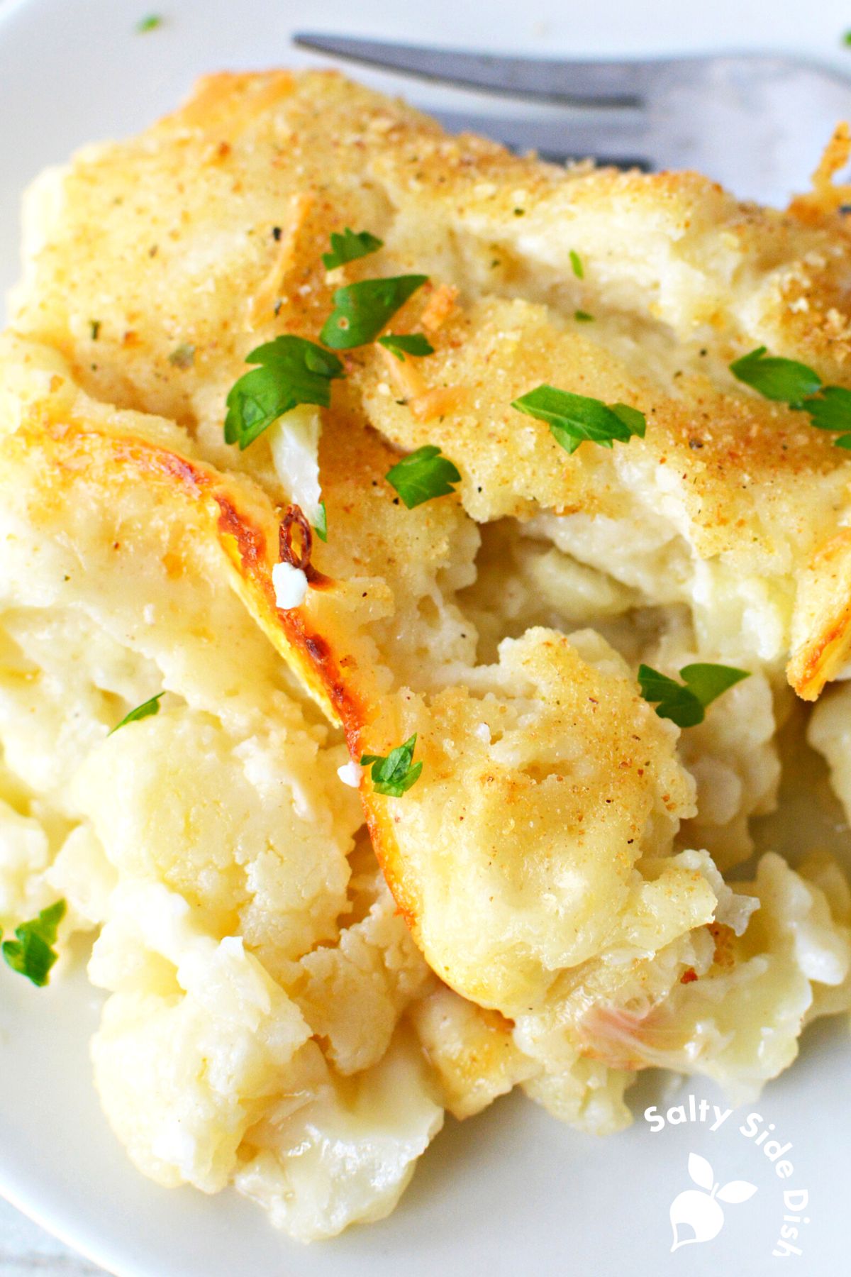 baked cauliflower casserole piled up on a white plate.