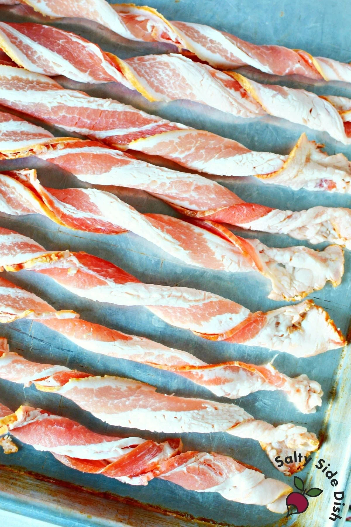 plate of twisted bacon on a sheet pan.